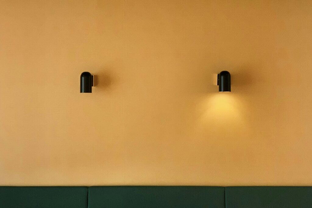 A pair of stylish lamps mounted on the wall, providing soft lighting in a well-decorated room