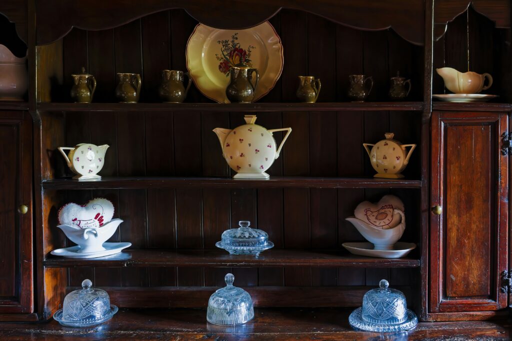 A wooden cabinet filled with an assortment of elegant glassware, showcasing various shapes and colors