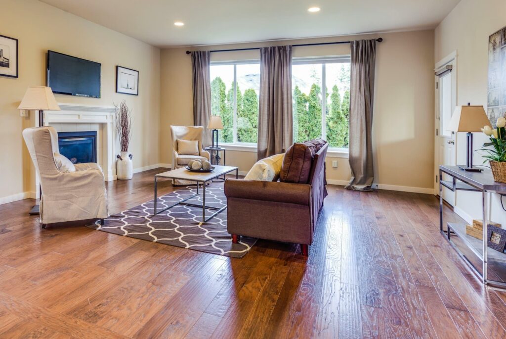 living room with brown sofa and whit chair and wood floor