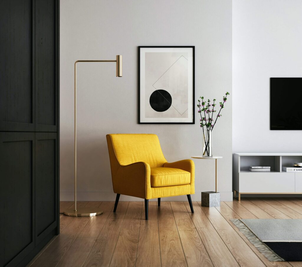 A cozy living room featuring a bright yellow chair and a television, creating a welcoming atmosphere for relaxation