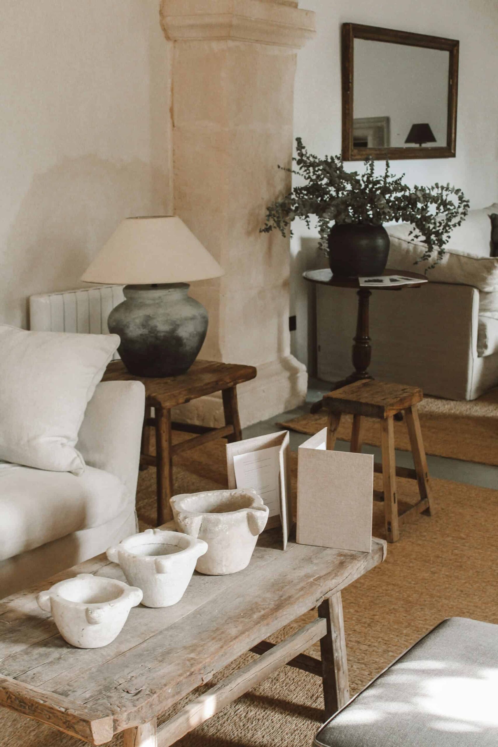 A cozy living room featuring a boho decor style with a couch, coffee table, and a stylish lamp.