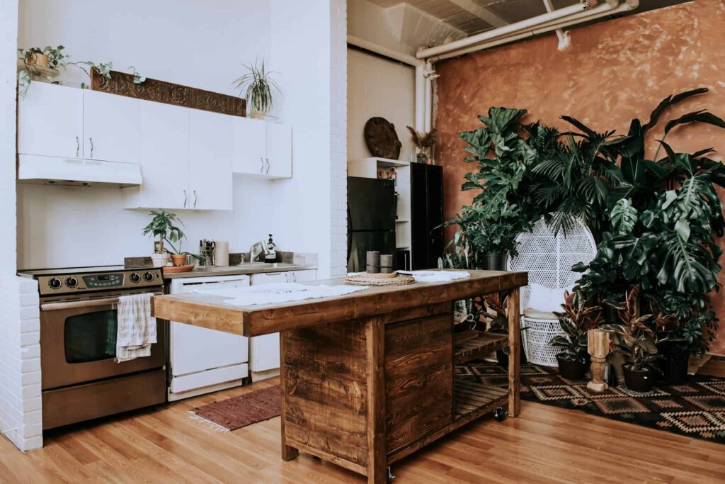 A cozy farmhouse kitchen decor featuring a wooden table adorned with vibrant plants, creating a warm and inviting atmosphere.