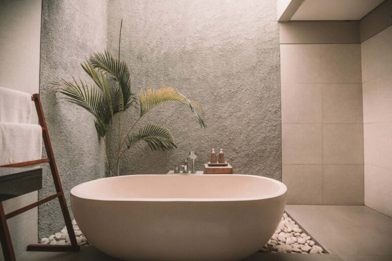 A serene bathroom featuring a stylish bathtub accompanied by a vibrant green plant for a refreshing touch.