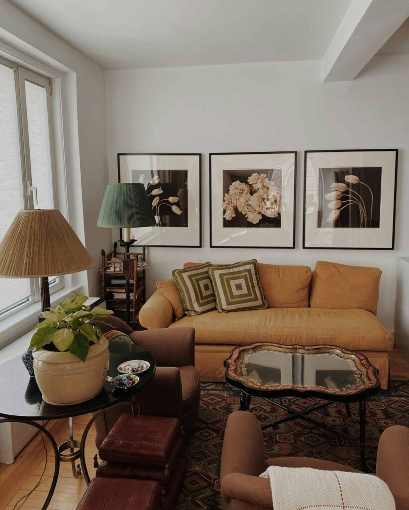 A cozy living room featuring a couch, coffee table, and lamp, showcasing a delightful mix of patterns in decor