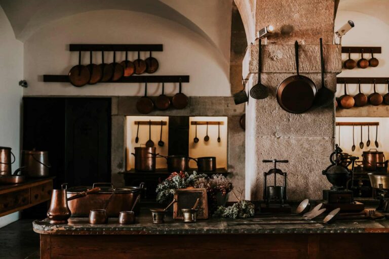 A cozy farmhouse kitchen decor with an abundance of pots and pans displayed on the counter, emphasizing a warm, inviting space.