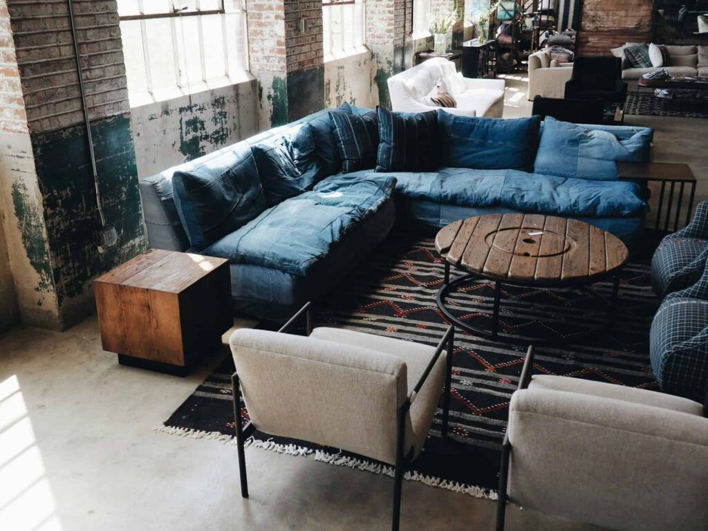 A cozy living room featuring blue couches arranged around a stylish coffee table