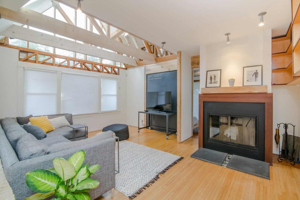 A stylish living room featuring an industrial decor theme, complete with a fireplace and a modern couch.